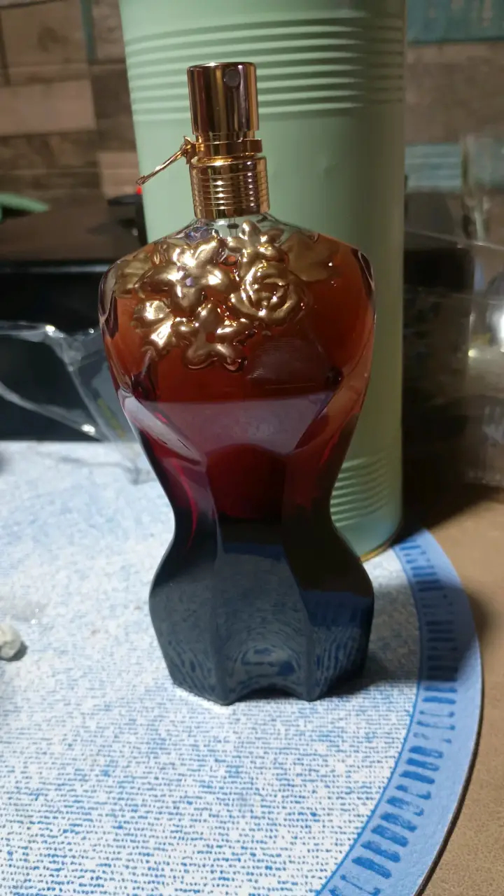 Perfume con diseño floral dorado