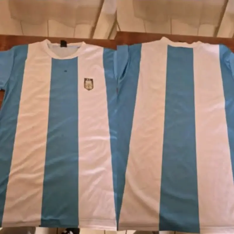 Camiseta de fútbol celeste y blanca con escudo