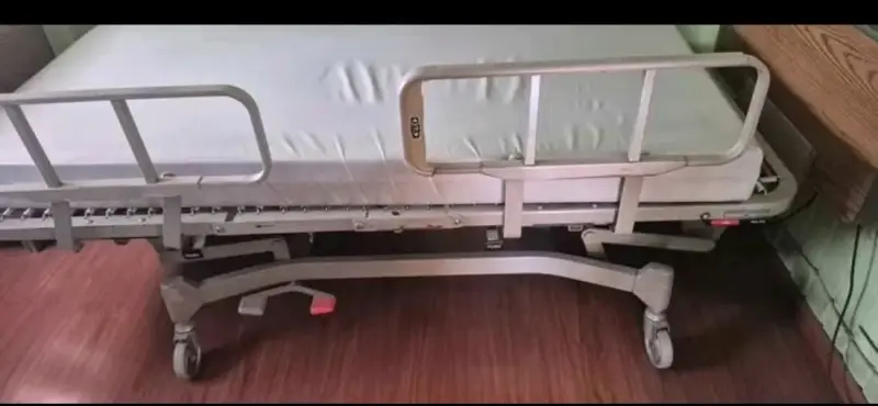 Cama clínica ajustable con barandas y ruedas