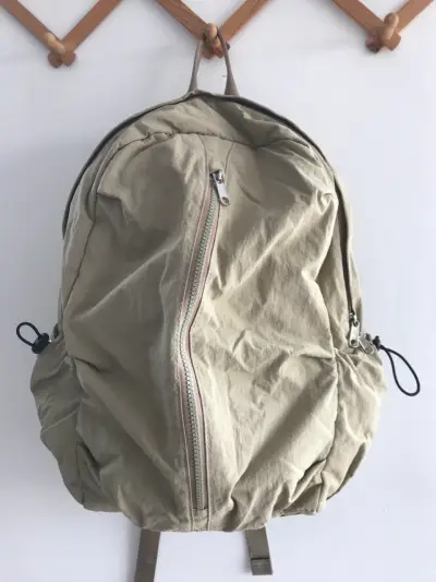 Mochila beige con múltiples compartimentos - miniatura 1