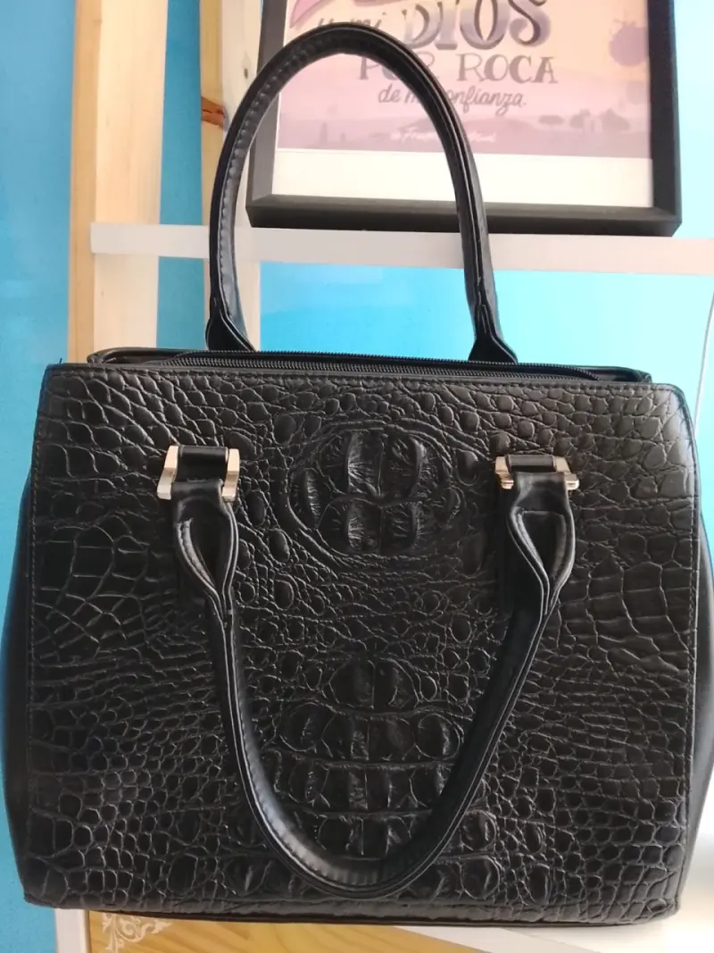 Bolso de mano negro con textura de cocodrilo
