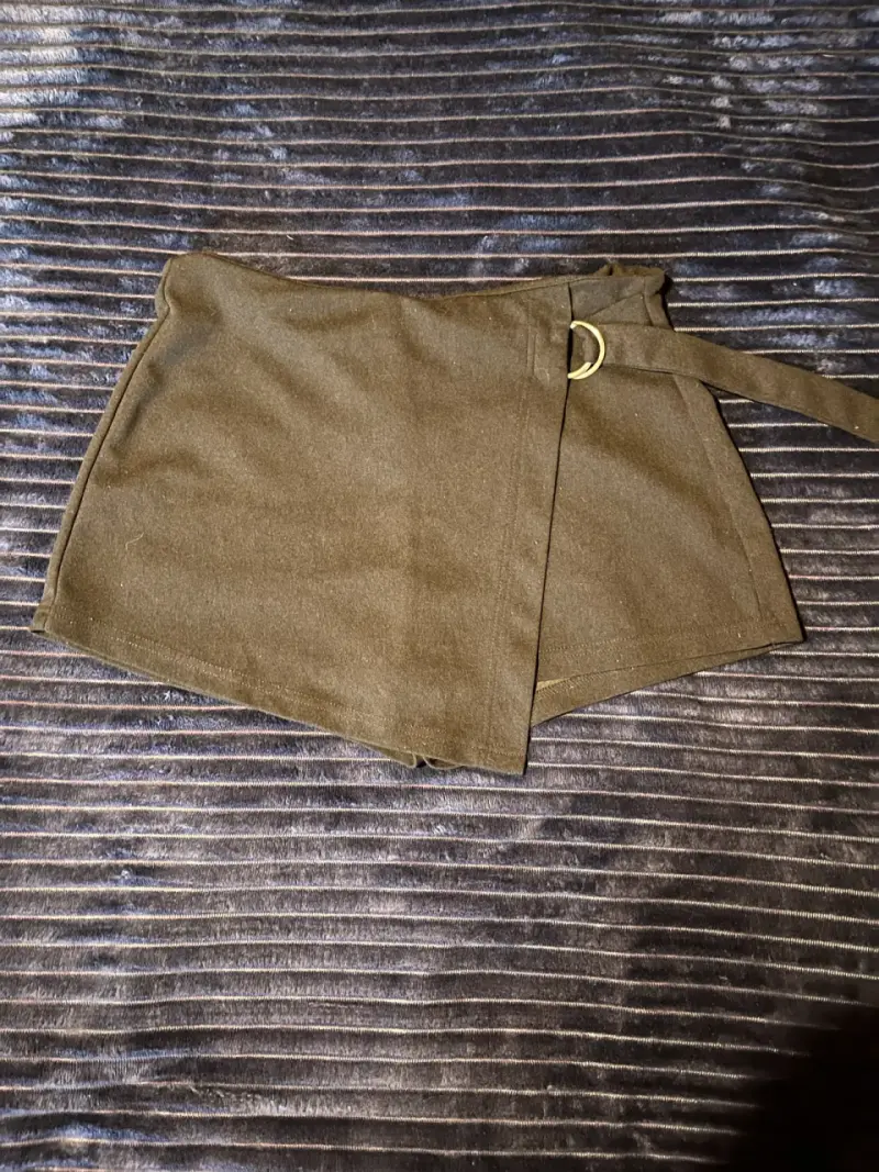 Falda short corta negra con hebilla metálica