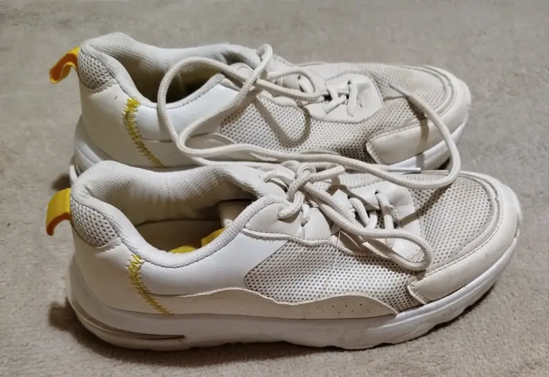 Zapatillas deportivas blancas con detalles amarillos
