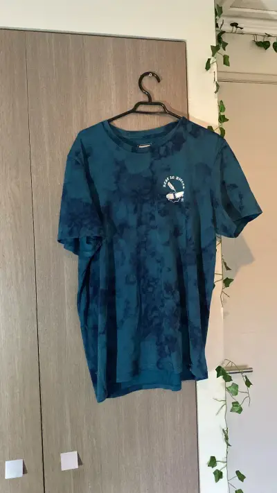Polera azul con diseño gráfico 'Rest in Pieces' - miniatura 1