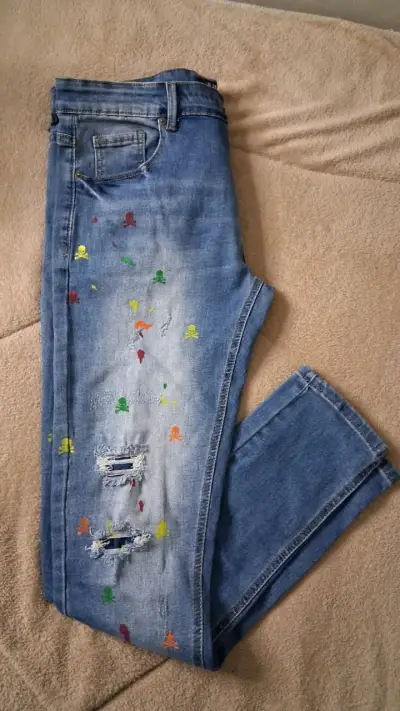 Jeans azul con diseño de calaveras coloridas - miniatura 1