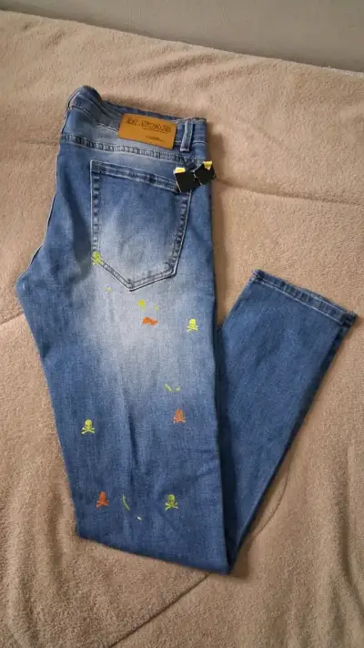 Jeans azul con diseño de calaveras coloridas - miniatura 2