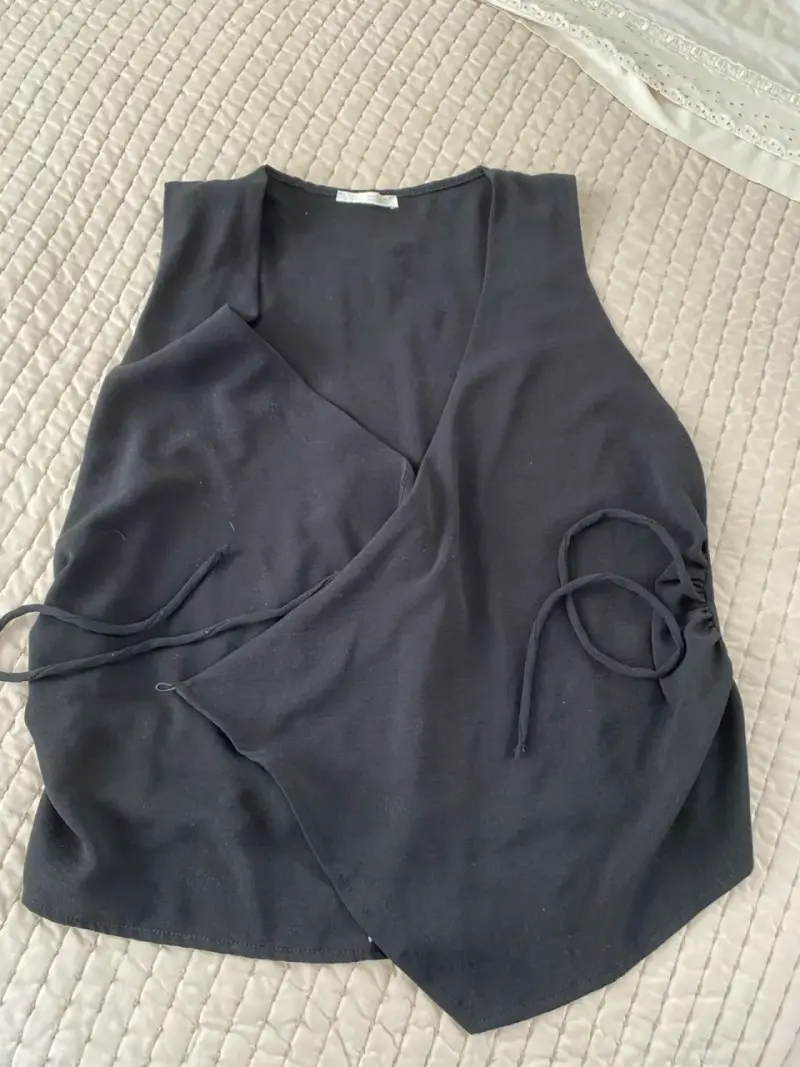 Blusa negra sin mangas con diseño cruzado