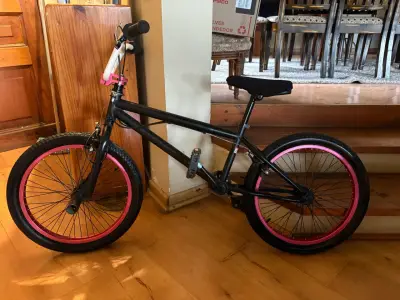 Bicicleta BMX negra con llantas rosadas - miniatura 1
