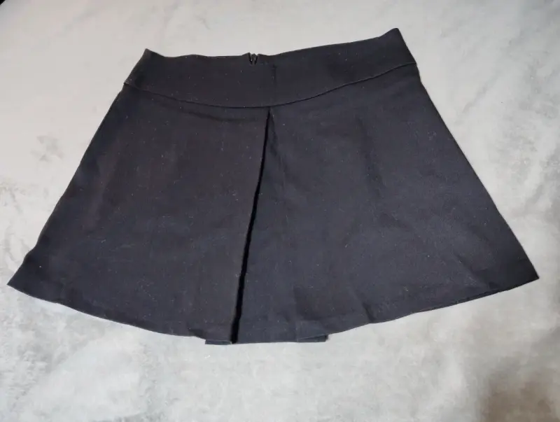 Falda corta negra con pliegue