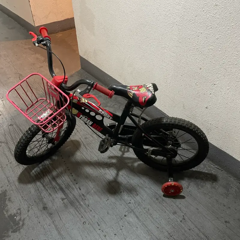 Bicicleta infantil con rueditas y canasto rojo