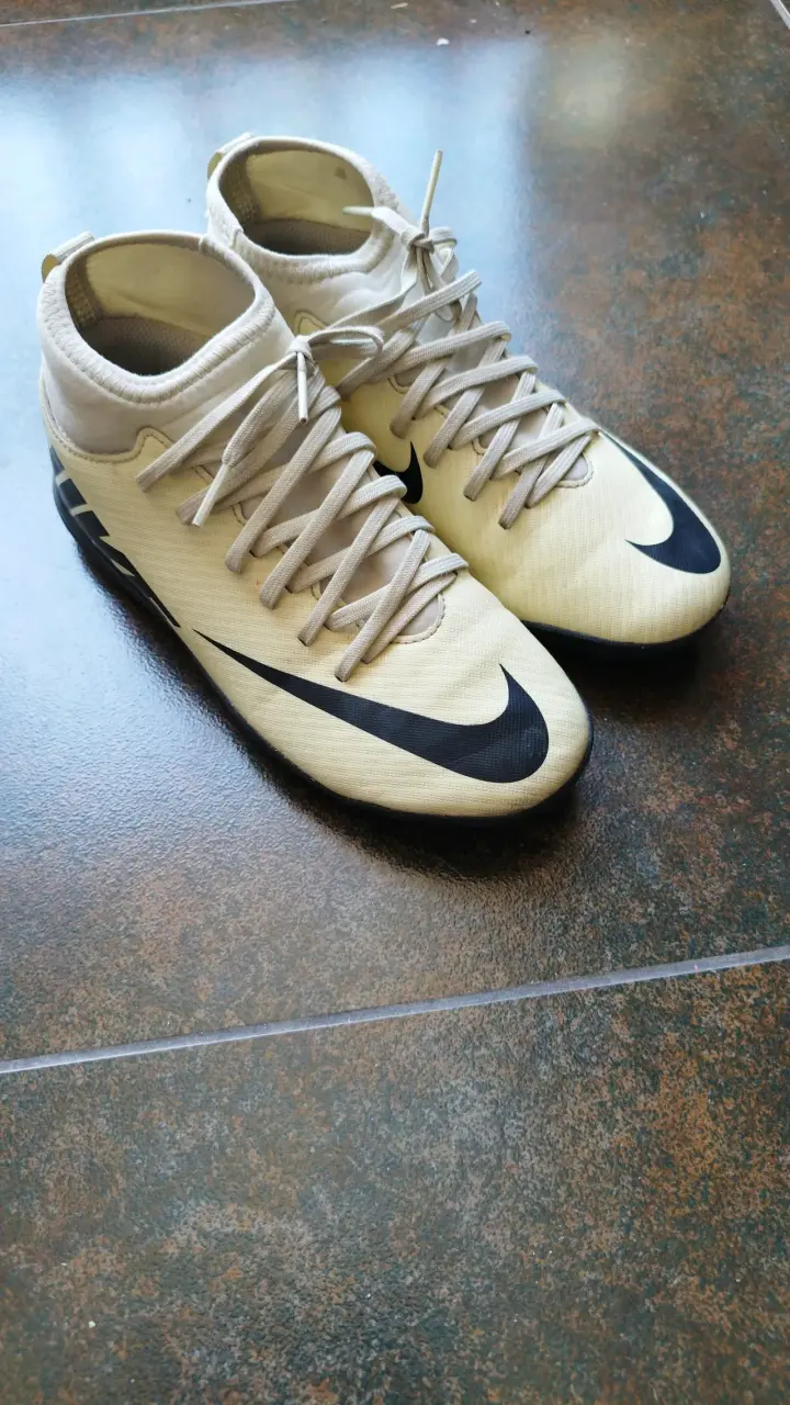 Botines de fútbol Nike beige con logo