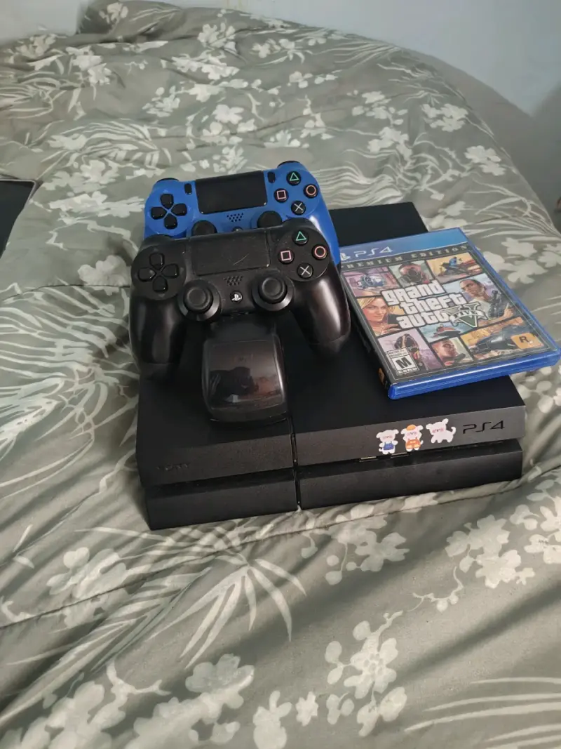 Consola PS4 con dos controles y juego GTA V - 2