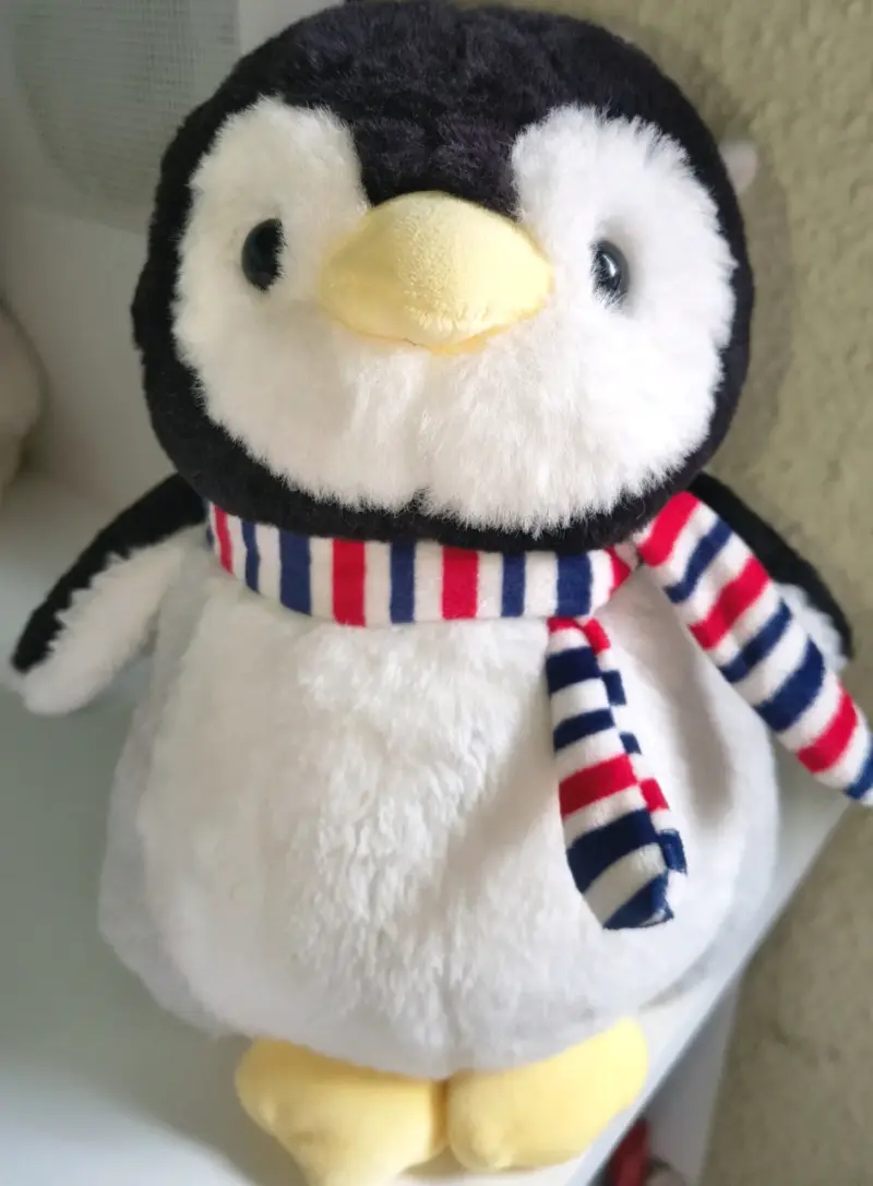 Peluche de pingüino con bufanda a rayas