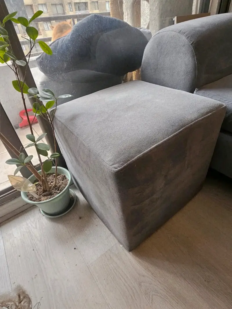 Sofá gris con cojines y puff - 2