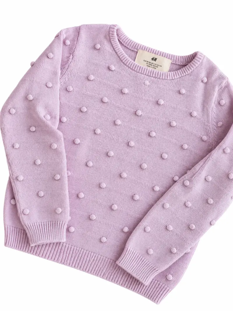 Suéter de punto lila con pompones para niña