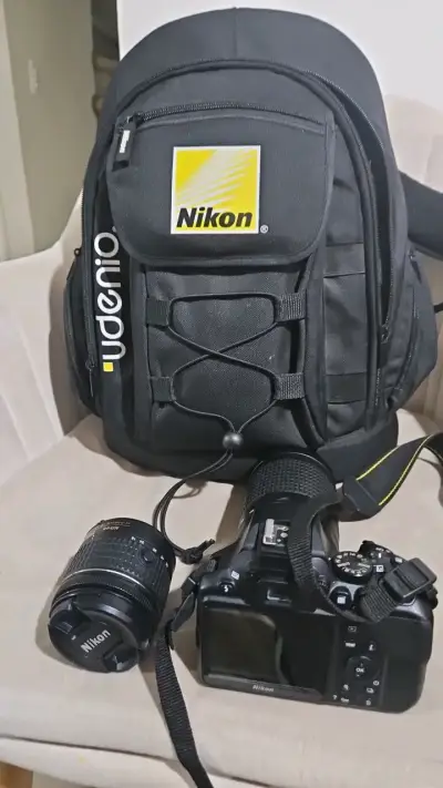 Cámara Nikon DSLR con lente y mochila - miniatura 1