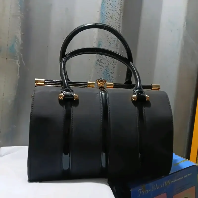 Bolso de mano negro elegante con detalles dorados - 1