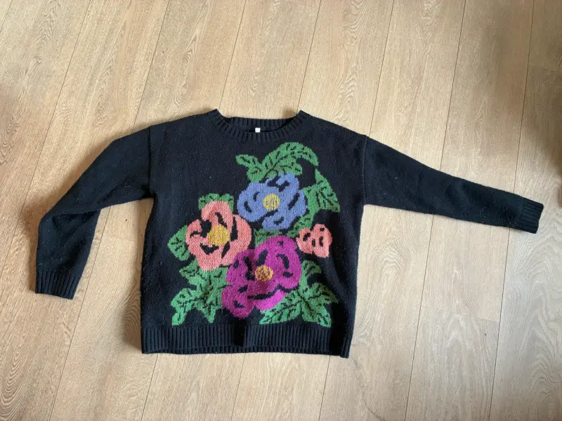Suéter negro con diseño floral colorido