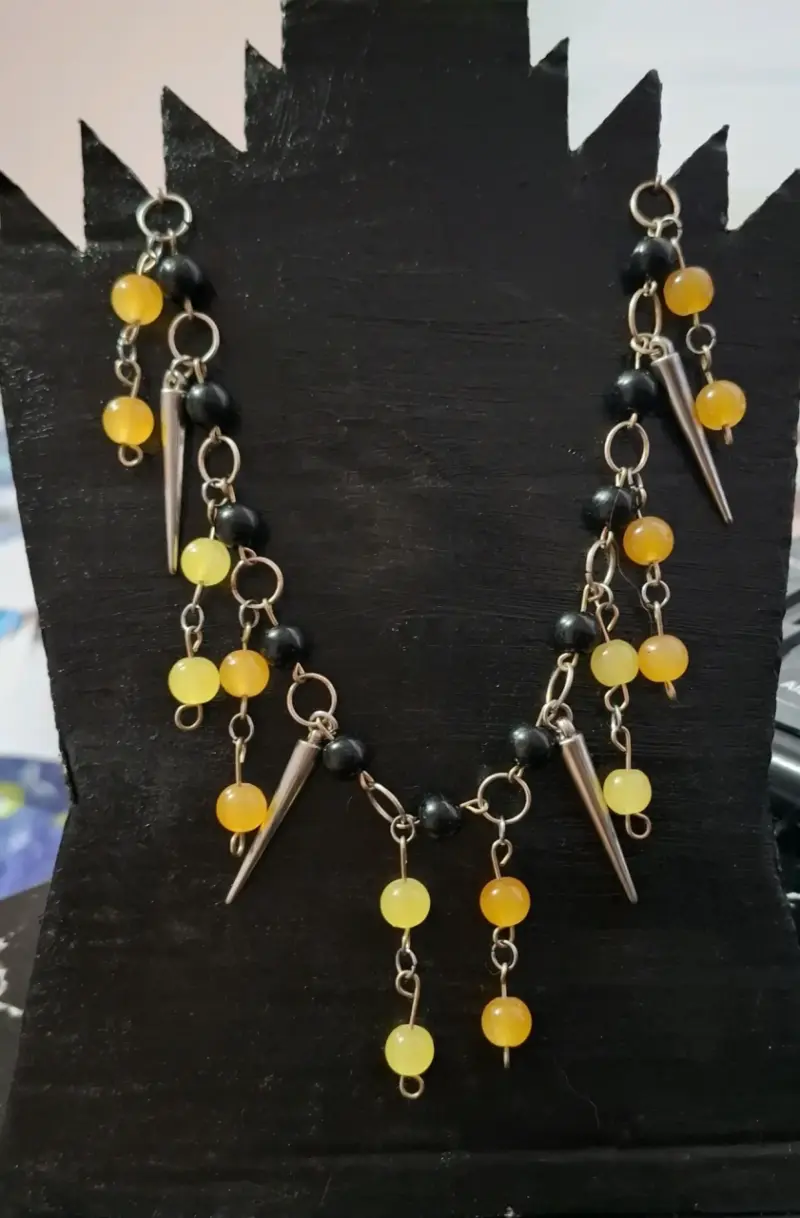 Collar de cuentas negras y amarillas con colgantes