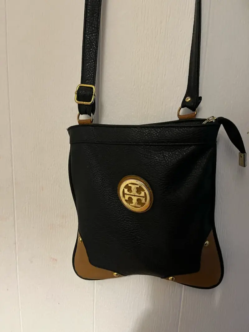Cartera cruzada negra con detalles dorados - 1
