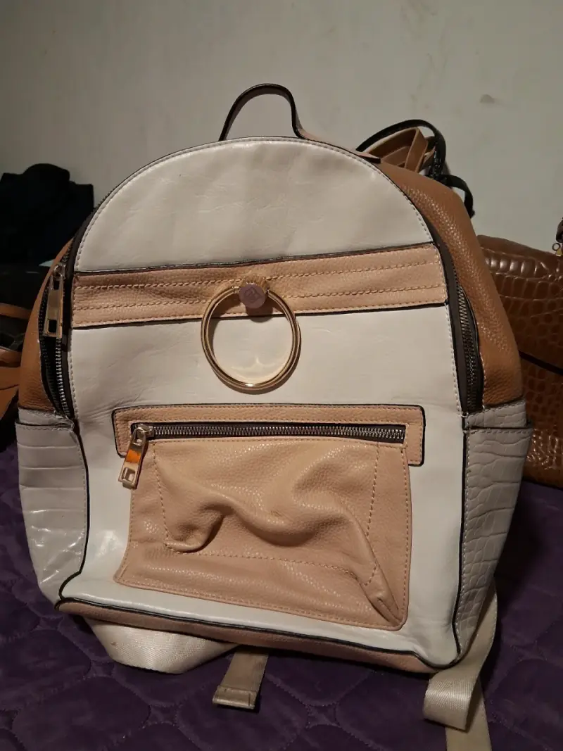 Mochila de cuero beige y blanca con aro decorativo