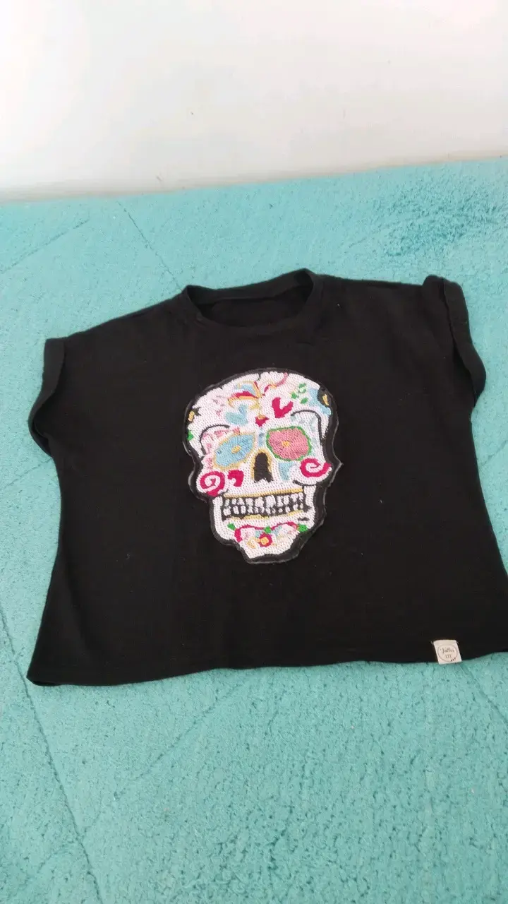 Polera negra con diseño de calavera bordada