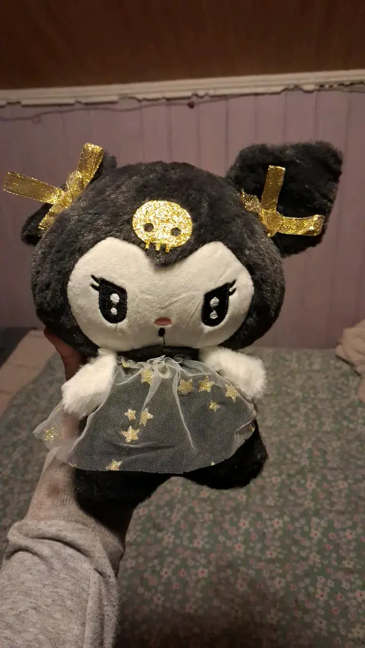 Peluche de personaje con vestido y lazo dorado
