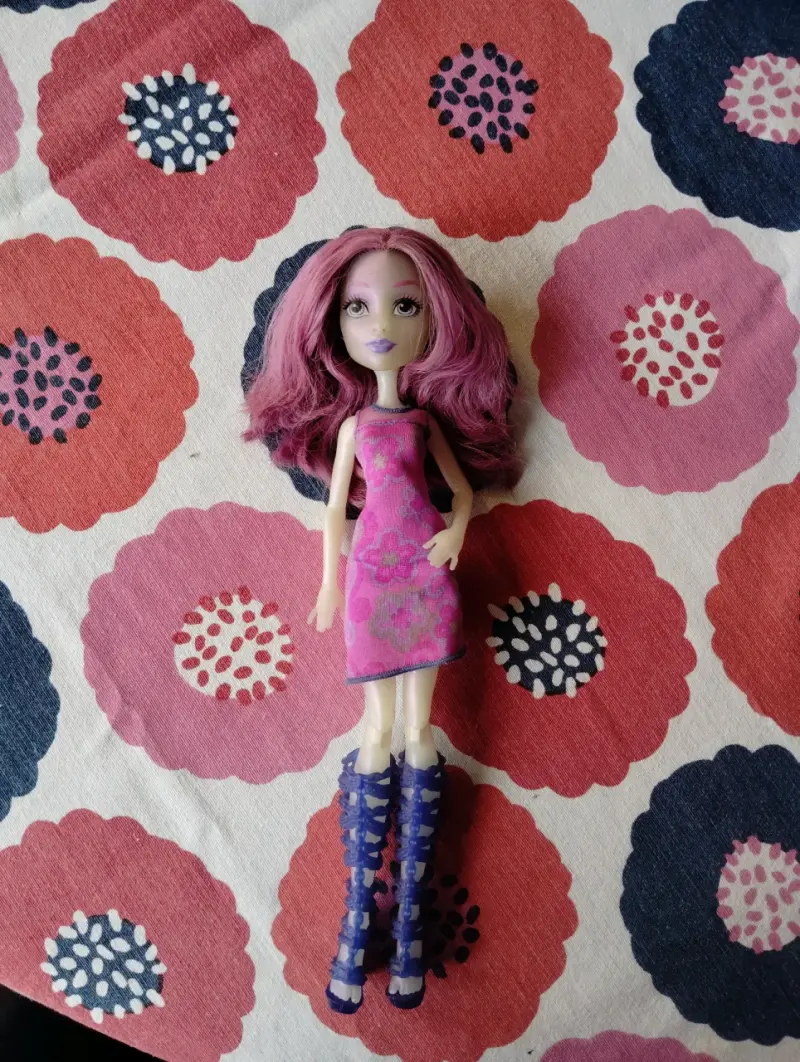 Muñeca de moda con cabello rosa y vestido floral