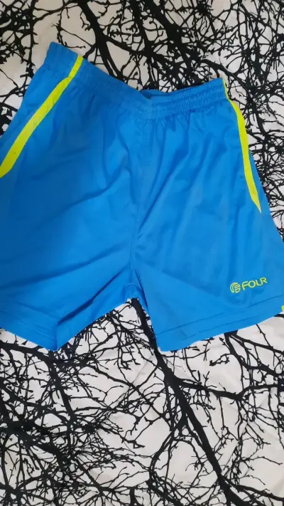 Shorts deportivos azules con detalles amarillos - miniatura 1