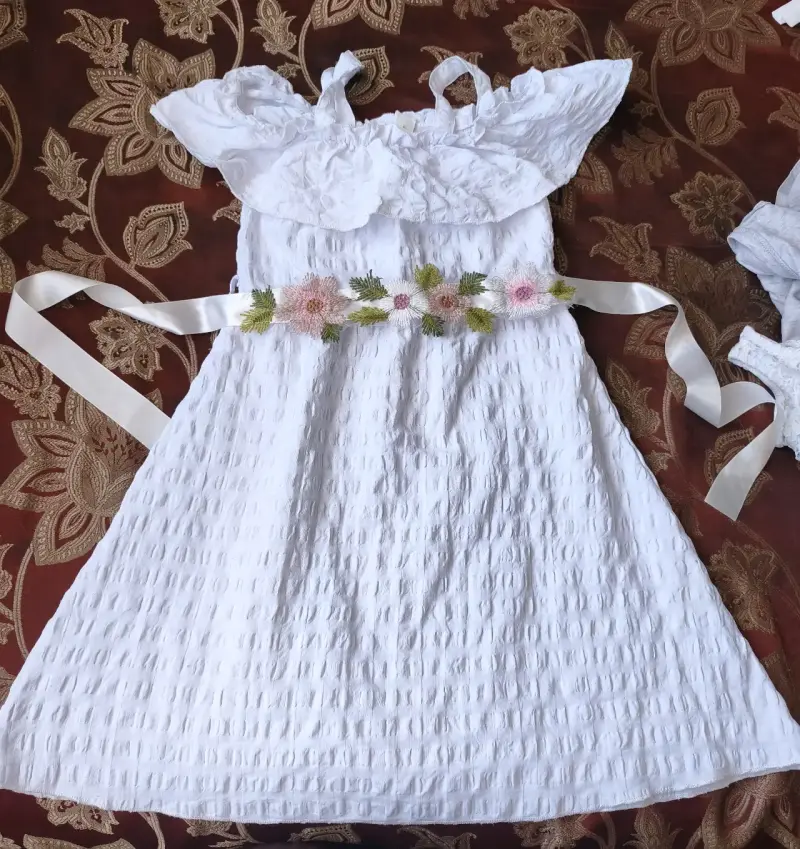Vestido blanco con flores y cinturón decorativo