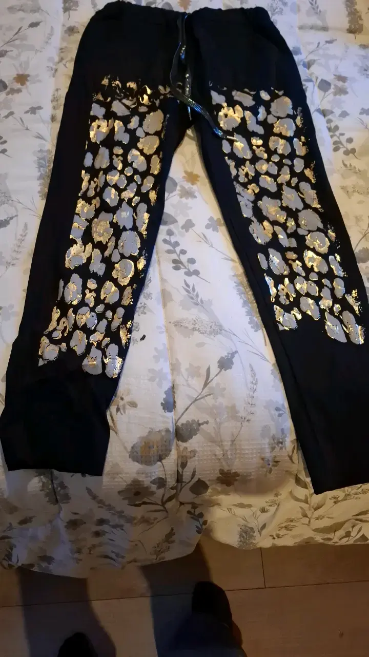 Pantalones deportivos negros con estampado dorado