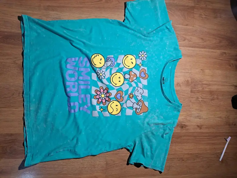 Polera turquesa Smiley World con estampado