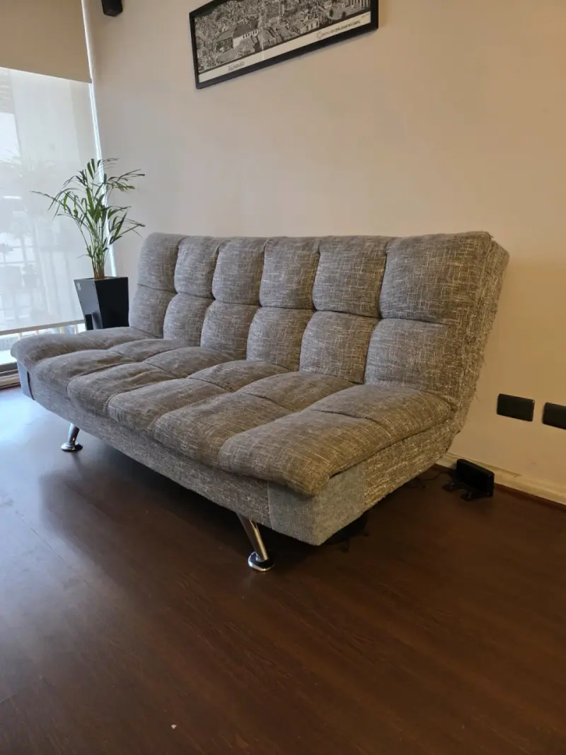 Sofá cama gris con patas metálicas