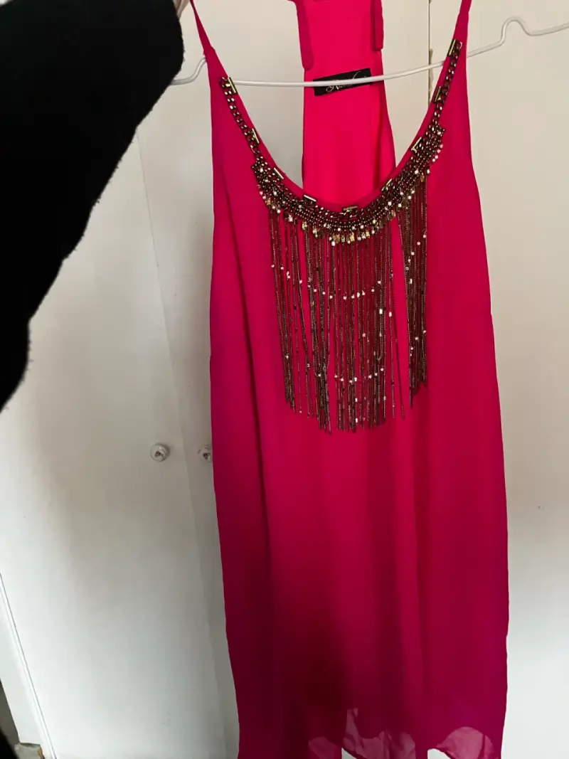 Vestido fucsia con detalles de flecos brillantes