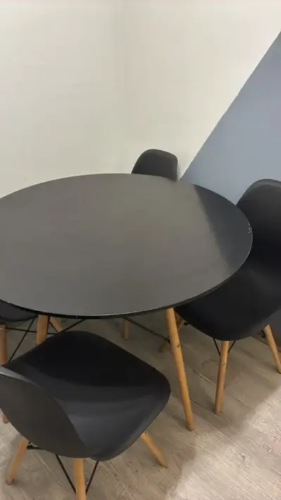Mesa redonda negra con sillas de madera EAMES - miniatura 1
