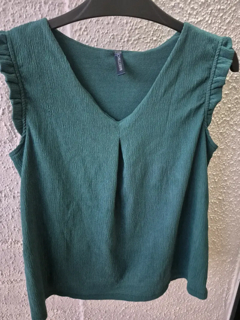 Blusa verde sin mangas con diseño plisado