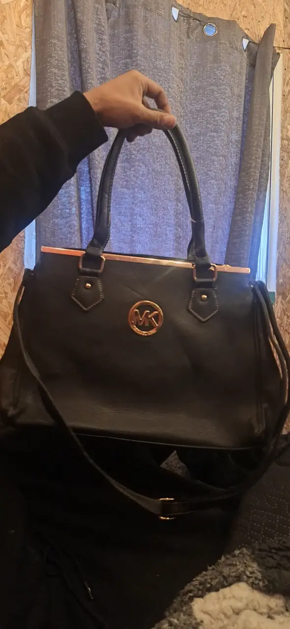 Bolso de mano negro con logo dorado