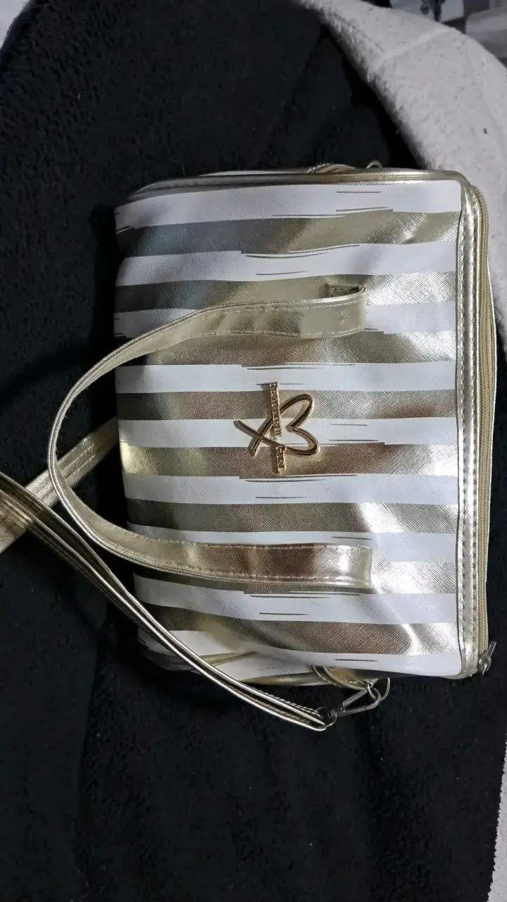 Bolso de mano dorado con diseño a rayas