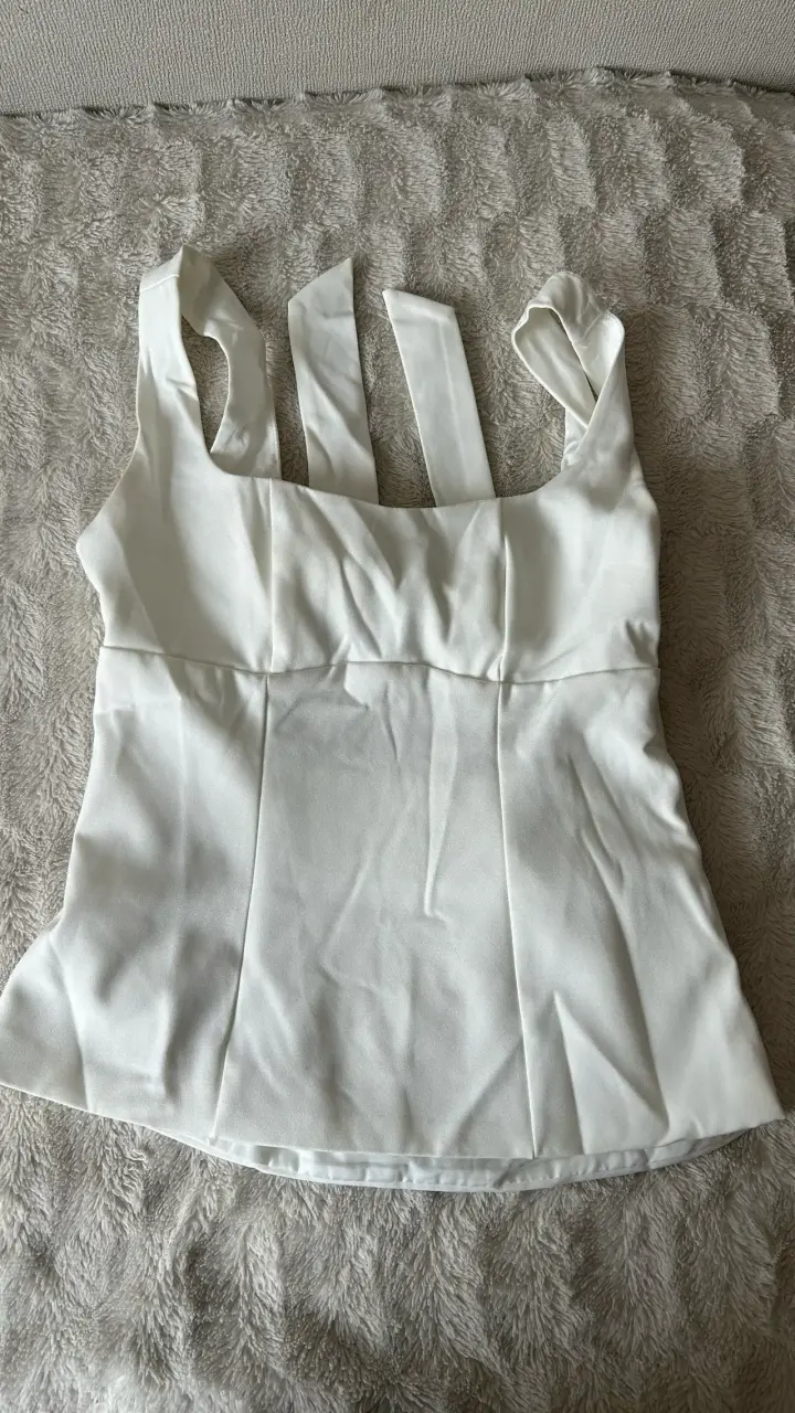 Blusa blanca sin mangas con lazo decorativo
