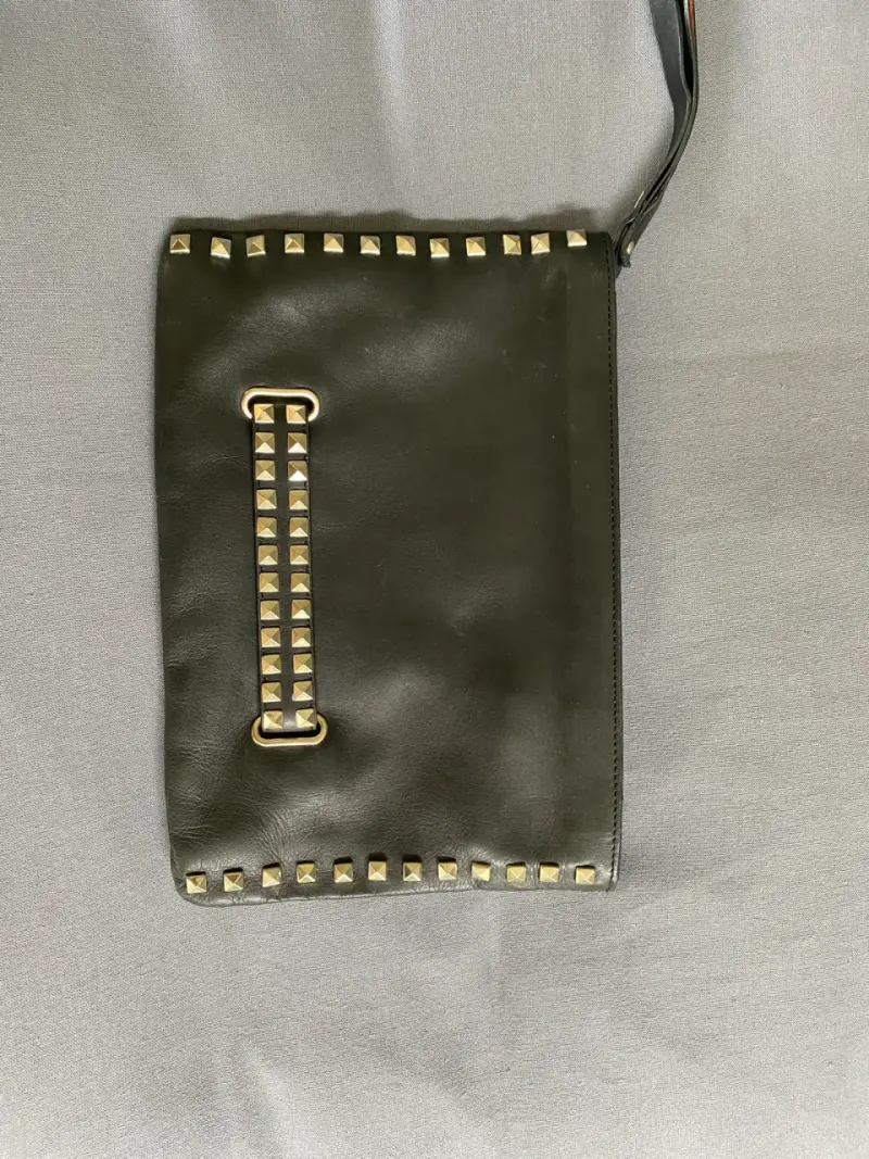 Cartera de mano negra con tachas metálicas