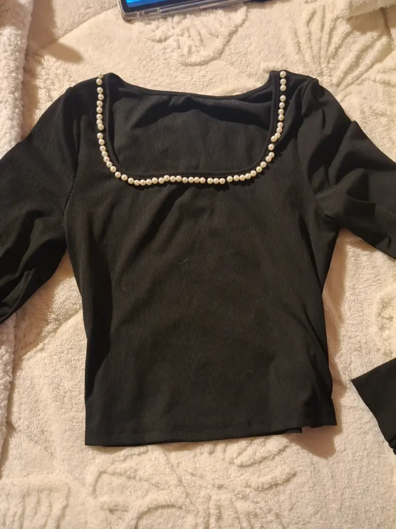 Polera negra con perlas en el cuello