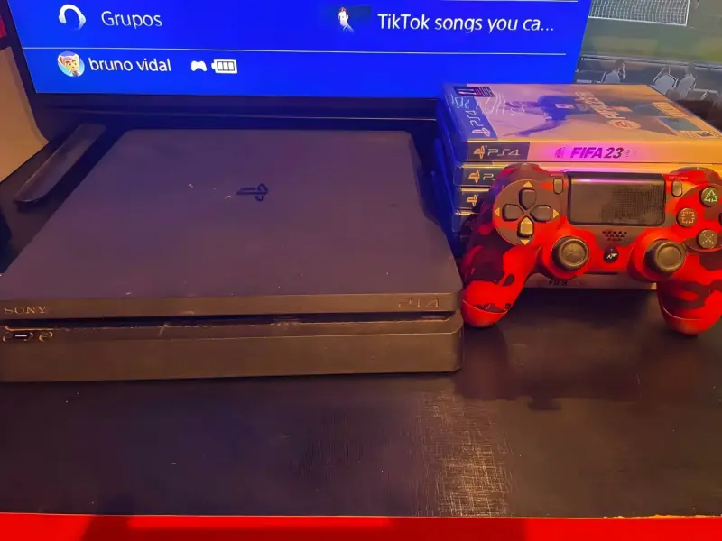 Consola PlayStation 4 con juegos y control rojo