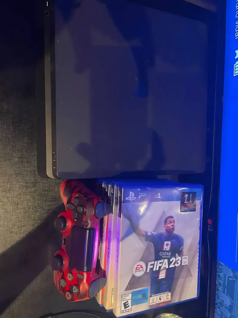 Consola PlayStation 4 con juegos y control rojo - 2