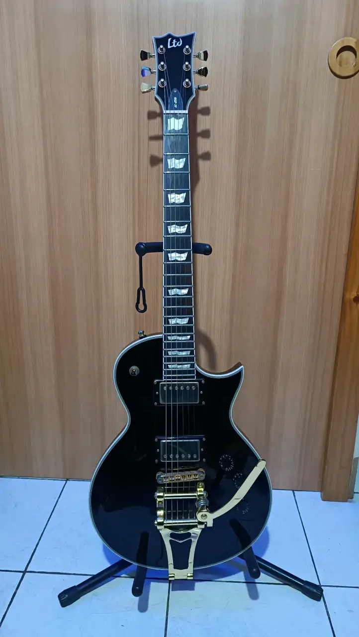 Guitarra eléctrica LTD negra con puente dorado