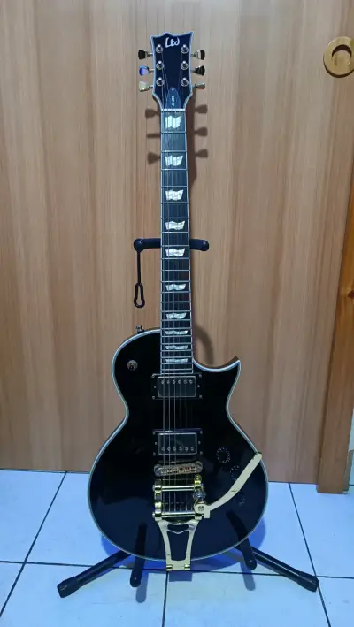 Guitarra eléctrica LTD negra con puente dorado - miniatura 1