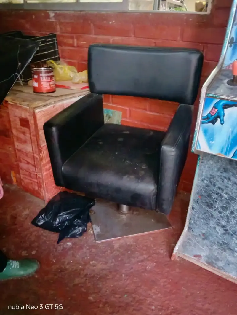 Silla de peluquería negra con base metálica