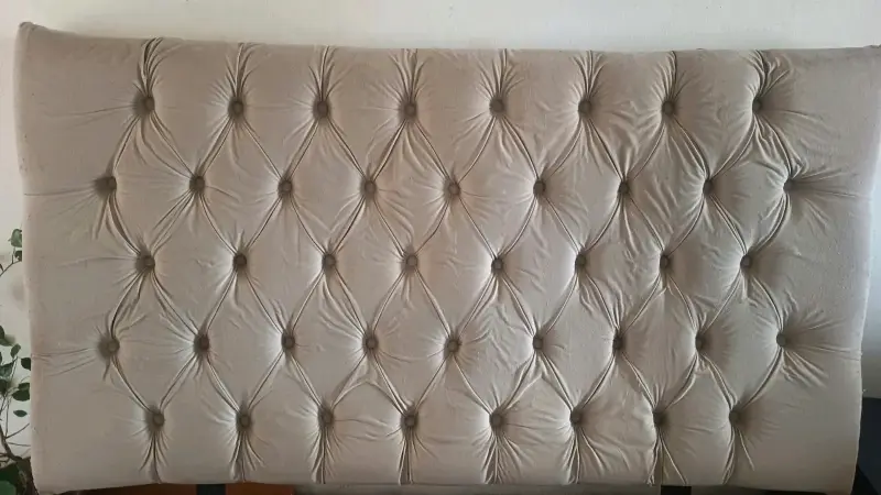 Cabecero tapizado beige con diseño capitoné