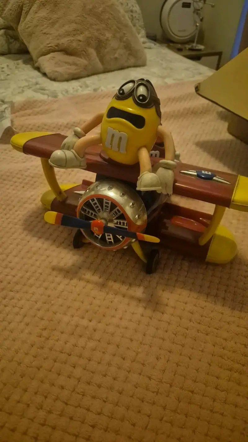 Figura coleccionable M&M en avión biplano