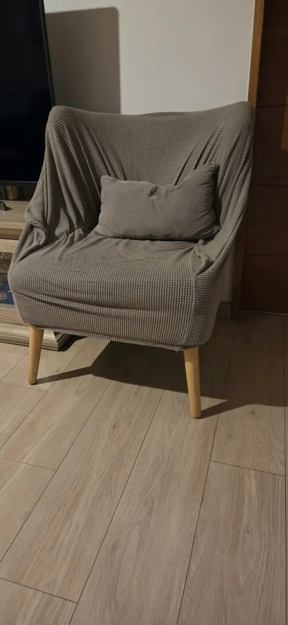Sillón tapizado gris con cojín