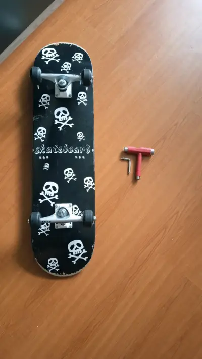 Skateboard con diseño de calaveras y llave T - miniatura 1